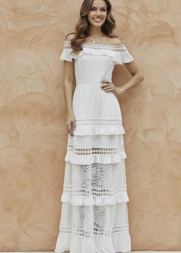 Woman in a white Alexa lace dress standing in front of a terrazzo wall