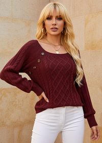 Woman wearing Anya burgundy sweater with a textured pattern against a beige wall.