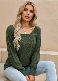 Woman wearing Anya green sweater sitting on a beige surface