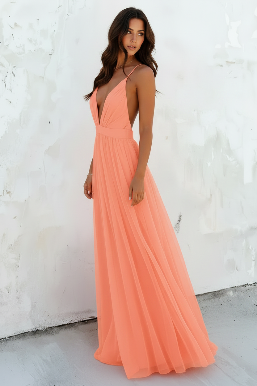 Woman wearing a peach-colored dress against a white wall