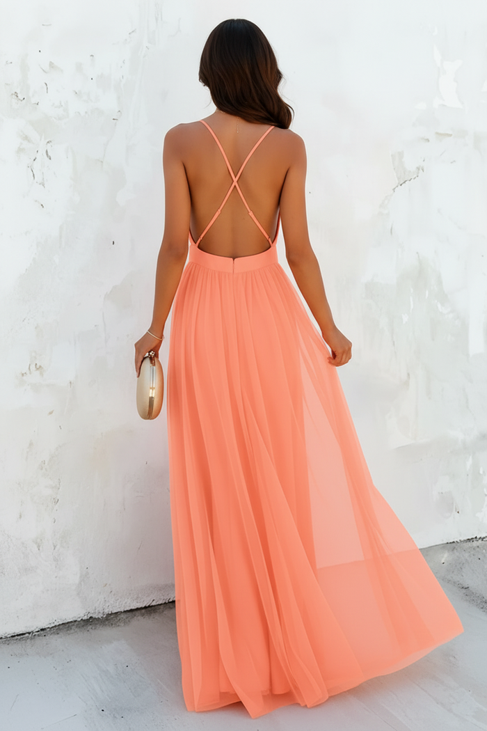 Woman wearing a peach-colored maxi dress with a white background