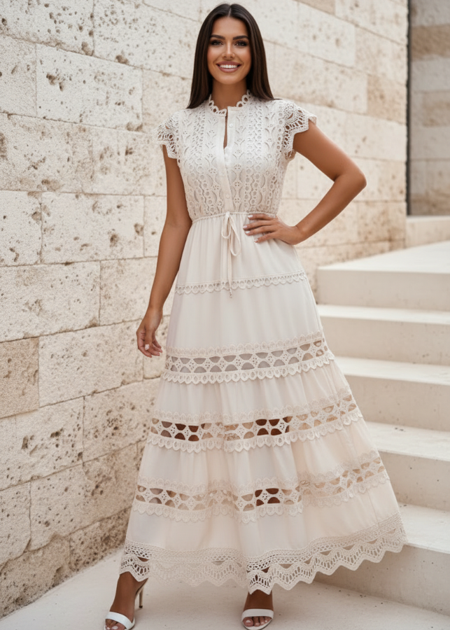 Woman wearing Danni Beige lace dress standing on stone steps with a stone wall background
