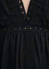 Black Janis dress with intricate detailing on a person wearing it. 
