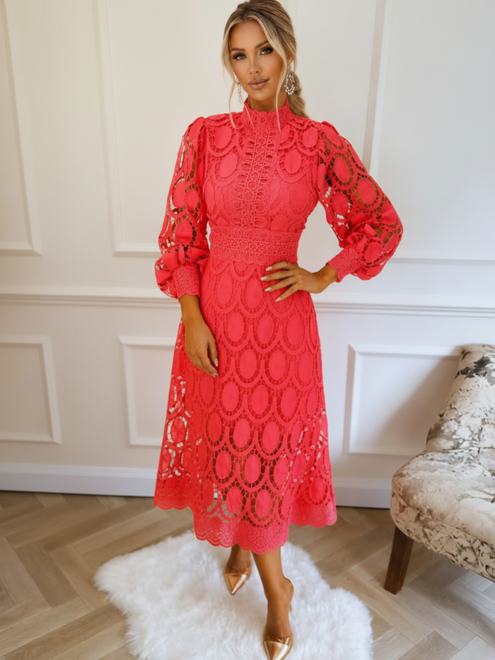 Woman wearing a Villa Vibes Jasmine Coral  lace dress in an elegant room setting.