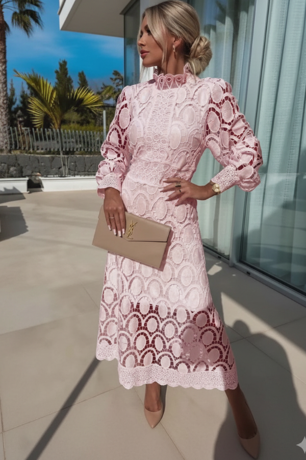 Woman in Jasmine pale pink lace dress standing outdoors with palm trees in the background