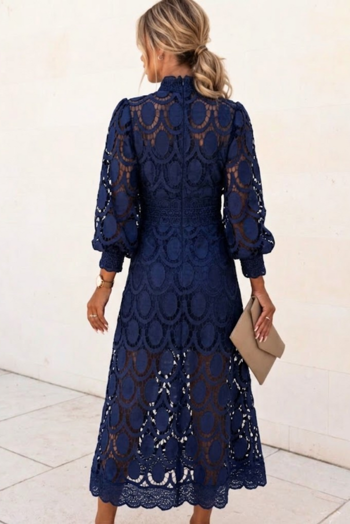 Woman wearing a Jasmine blue lace dress with long sleeves against a white background