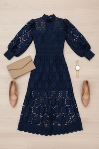 Navy blue Jasmine lace dress with beige clutch, shoes, and watch on a light wooden surface