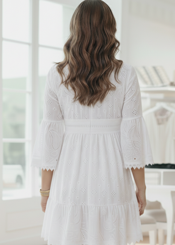 Woman wearing a white lace dress in a bright room