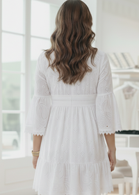 Woman wearing a white lace dress in a bright room