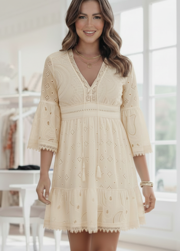 Woman wearing a cream lace dress in a bright room