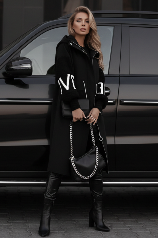 Woman standing next to a black SUV holding a handbag wearing Kelly Coat black