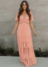 Woman wearing a pink lace dress against a neutral background