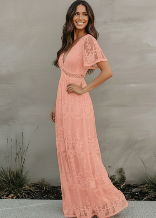 Woman wearing a pink lace dress standing against a neutral background