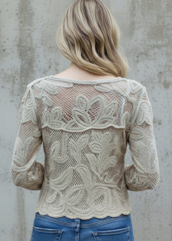 Person wearing Roxy beige lace top against a concrete wall