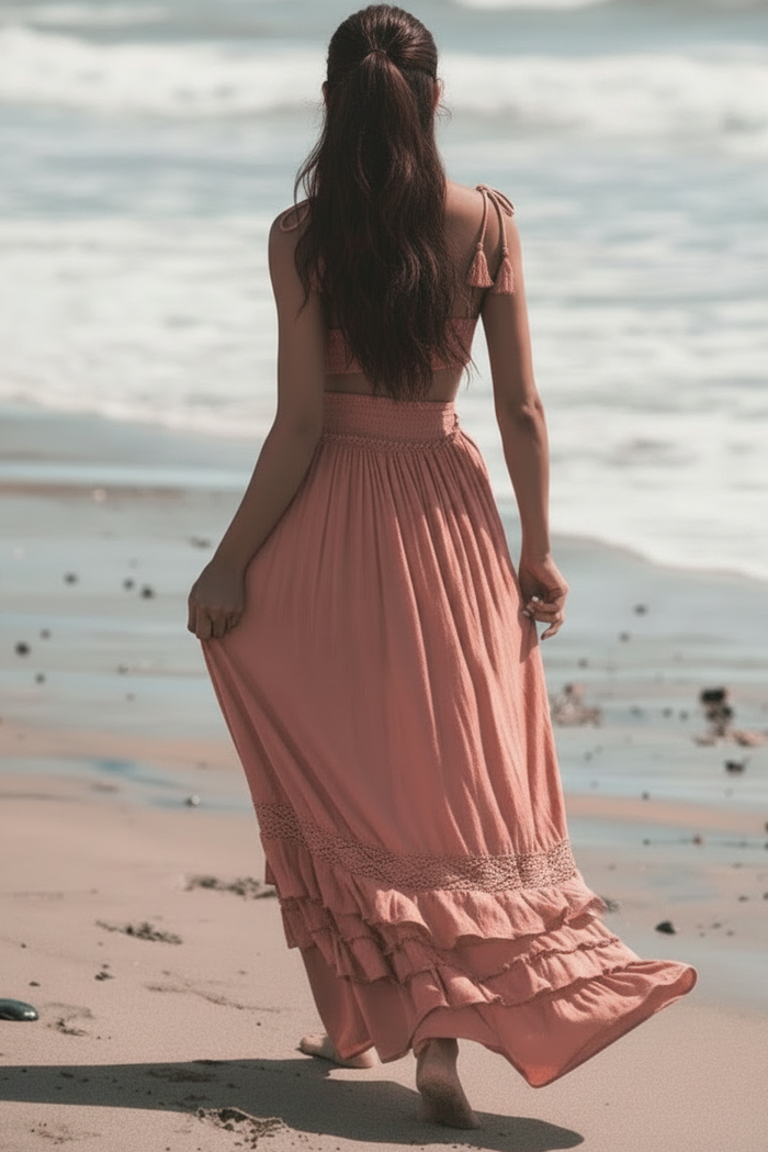 Woman in a Shakira blush dress walking on a beach