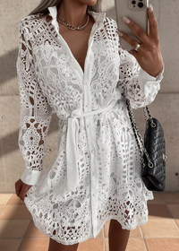 Person wearing Sienna white lace dress taking a mirror selfie.