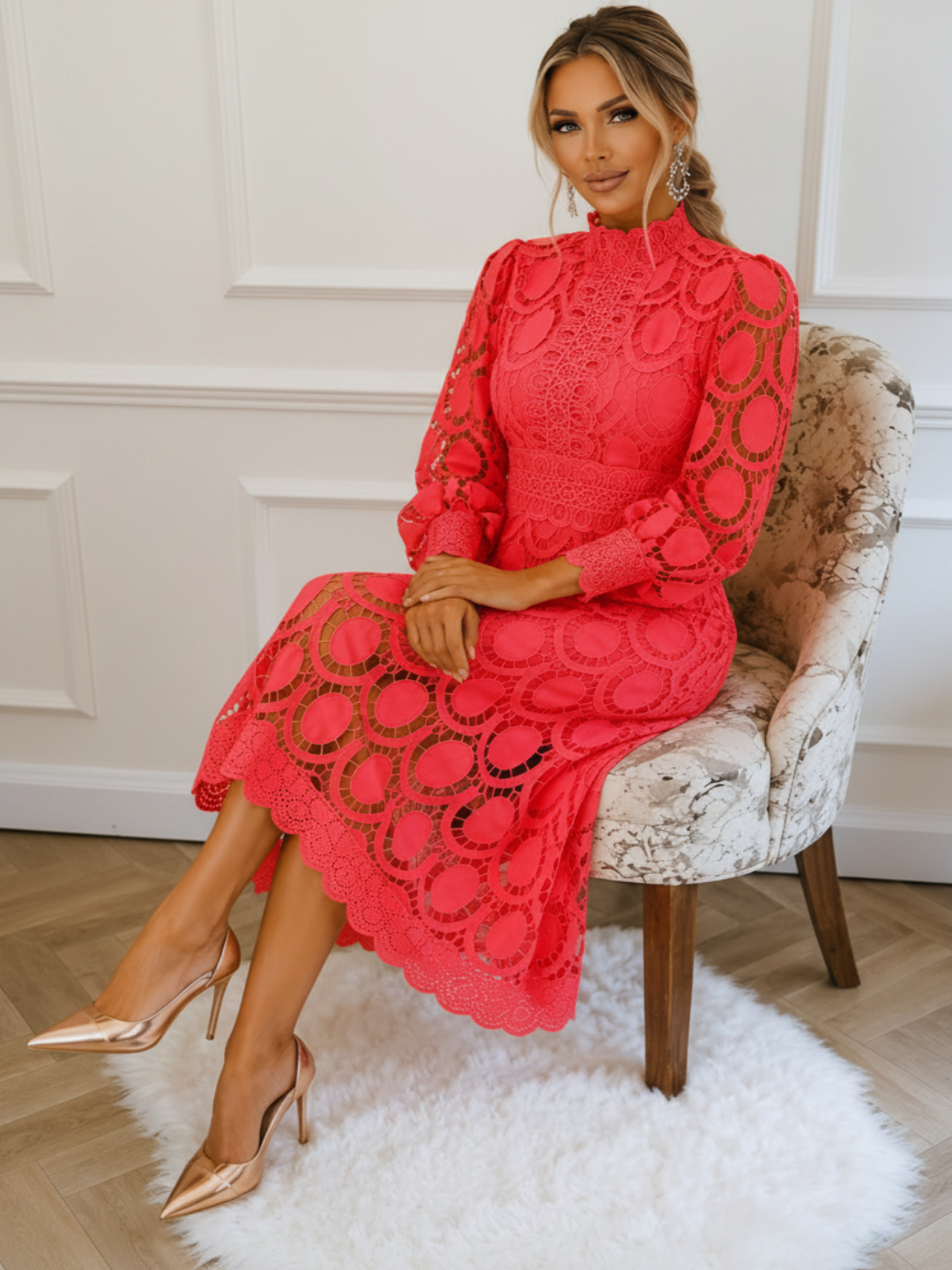 Woman in a Villa Vibes Jasmine Coral  dress sitting on a chair in an elegant room.