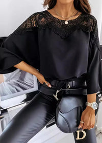Person wearing a St Barts Black Lace Top with lace details and black pants, sitting on a chair.
