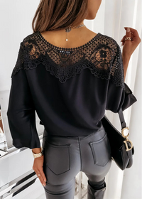 St Barts Black Lace Top with lace detailing worn by a person, sitting on a white chair.