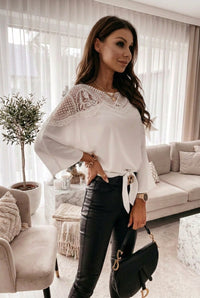 Woman wearing a St Barts White Lace Top with lace details in a decorated room.