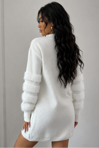 Woman wearing a Villa Vibes Tanner white sweater dress against a plain backgroud