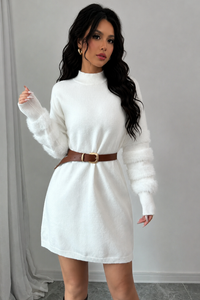 Woman wearing a Villa Vibes Tanner  white sweater dress with a brown belt against a gray background