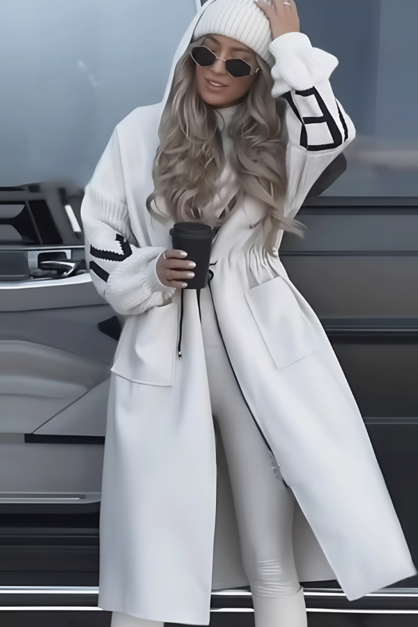 Person wearing a Villa Vibes Kelly long white coat with a car in the background