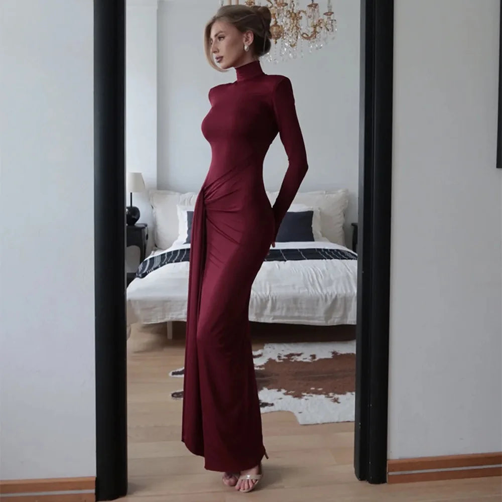 Woman in a Villa Vibes Allegra burgundy dress standing in front of a mirror in a bedroom.