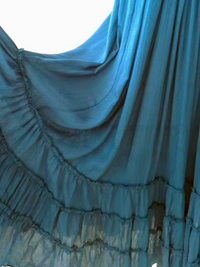 A close-up of Villa Vibes Anika blue ruffled fabric, likely a curtain or a long skirt, with gathered tiers and a sheer texture.