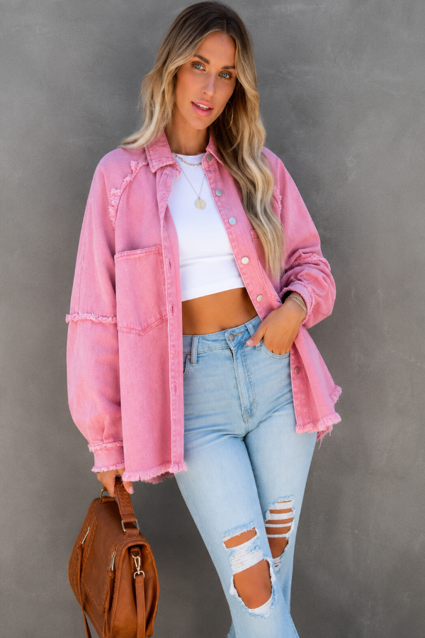 Woman wearing a Villa VIbes Brydie pink denim jacket, white top, and ripped jeans against a gray background