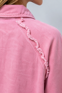 Close-up of a Villa Vibes Brydie  pink garment with lace trim on a plain background