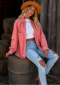 Model wearing Villa VIbes Brydie Pink Shirt wearing hat and brown bag sitting on barrell with hay shed behind