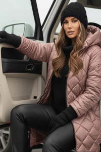 Woman in a Villa Vibes Cameron pink quilted coat and black beanie getting out of a car.
