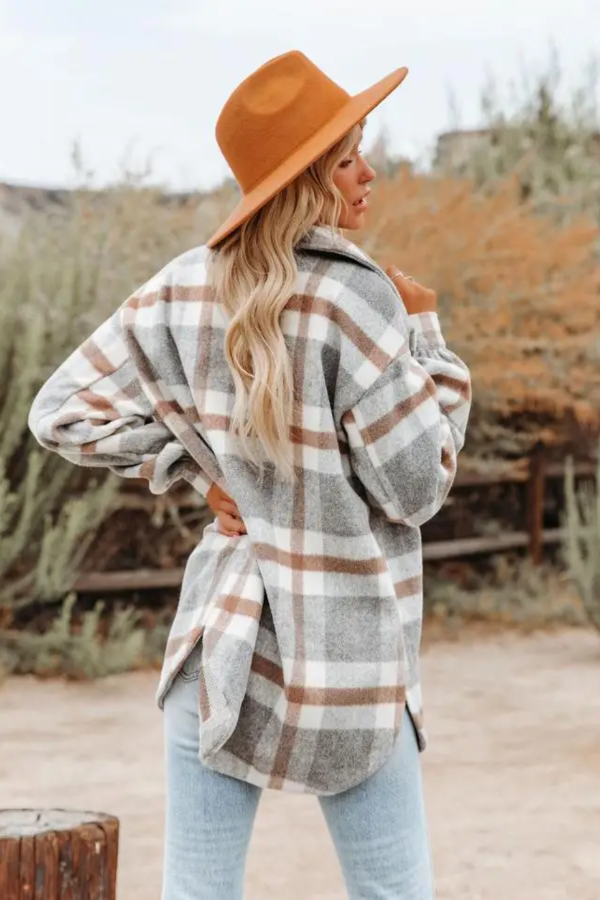 Person wearing a Villa Vibes Cassidy plaid shirt and brown hat in a desert-like setting