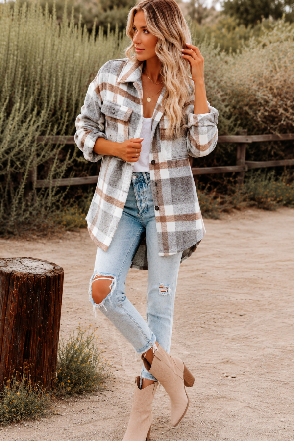 Woman wearing a Villa Vibes Cassidy plaid shirt and ripped jeans standing outdoors.