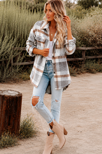 Woman wearing a Villa Vibes Cassidy plaid shirt and ripped jeans standing outdoors.