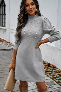 Woman wearing a Villa Vibes Chelsea gray sweater dress with pearl embellishments outdoors.