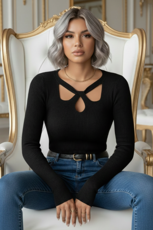 Woman sitting on an ornate chair wearing a Villa Vibes Dahlia black top and blue jeans.