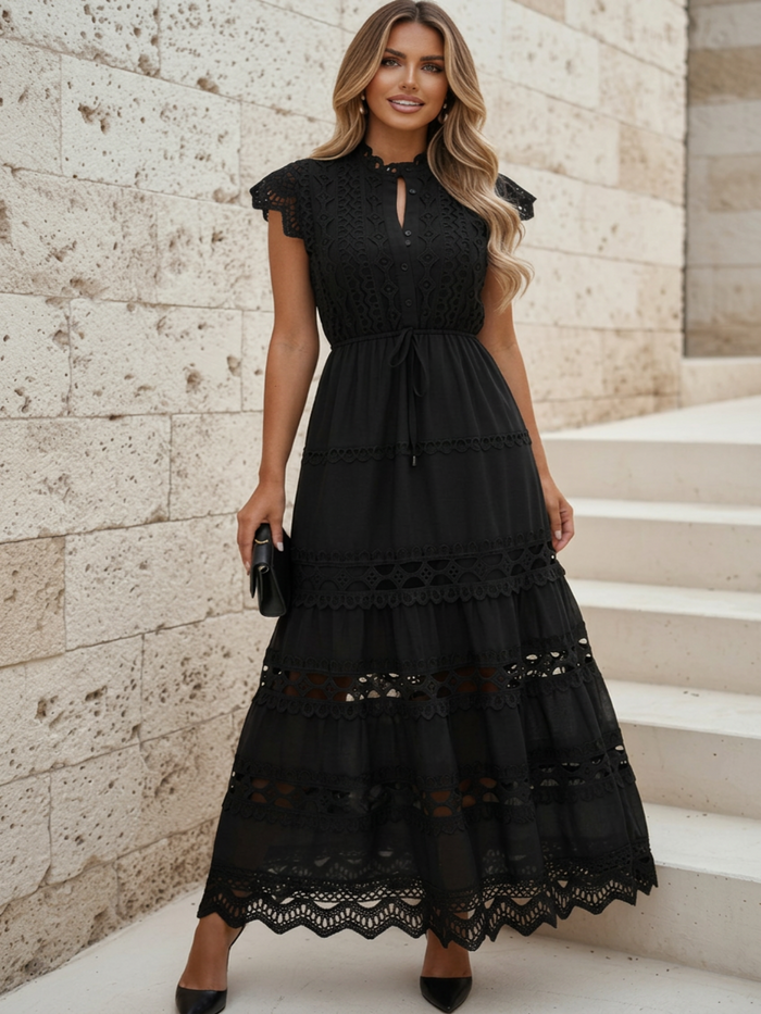 Woman wearing Villa Vibes Danni black lace dress standing on stone pavement