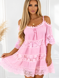 Woman wearing a Villa Vibes Fallon pink lace Fallon dress from Villa Vibes standing in front of a white plastered wall 