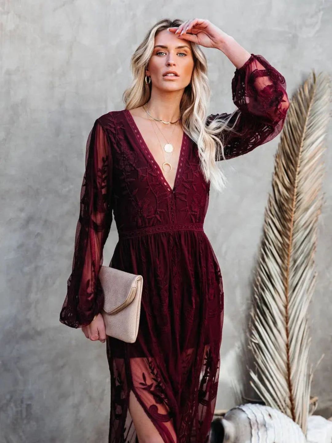 Woman wearing a Villa Vibes Janis burgundy lace dress against a neutral background