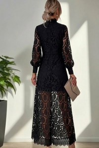 Woman wearing a Villa Vibes Jasmine black lace dress with long sleeves in a minimal indoor setting.