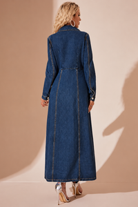Woman wearing a Villa Vibes Jordie long denim dress against a beige background