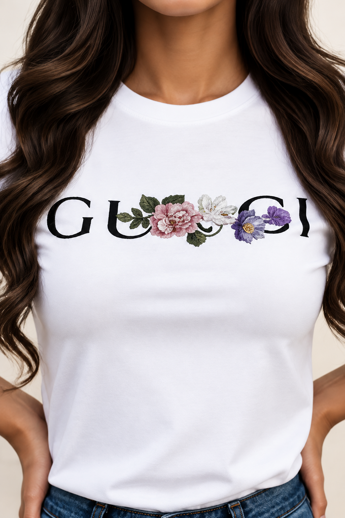 Villa Vibes White t-shirt with floral Gucci logo worn by a person with blonde hair.
