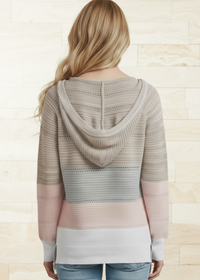 Woman wearing a Villa Vibes Pippa patterned hoodie with a neutral color scheme on a light background