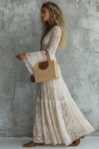 Woman wearing a Tessa Cream lace dress against a textured wall.