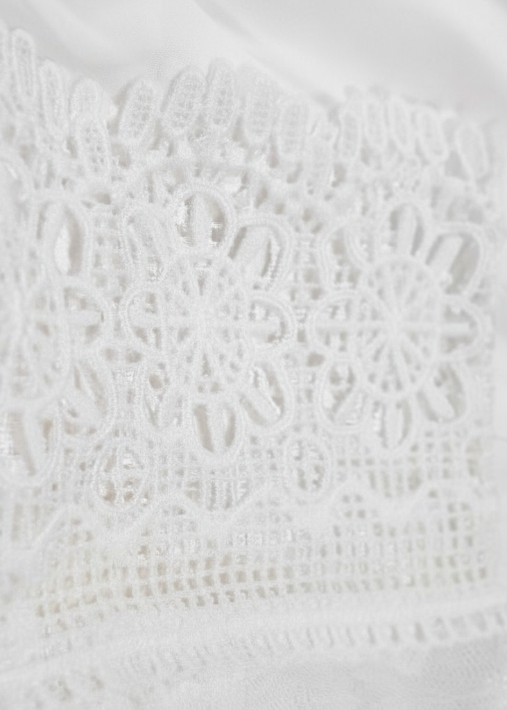 Close-up of a Villa Vibes  Fallon Dress textured white fabric with lace detailing