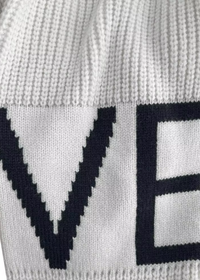 Close-up of White Kelly knit garment with 'LOVE' text in black on a white background