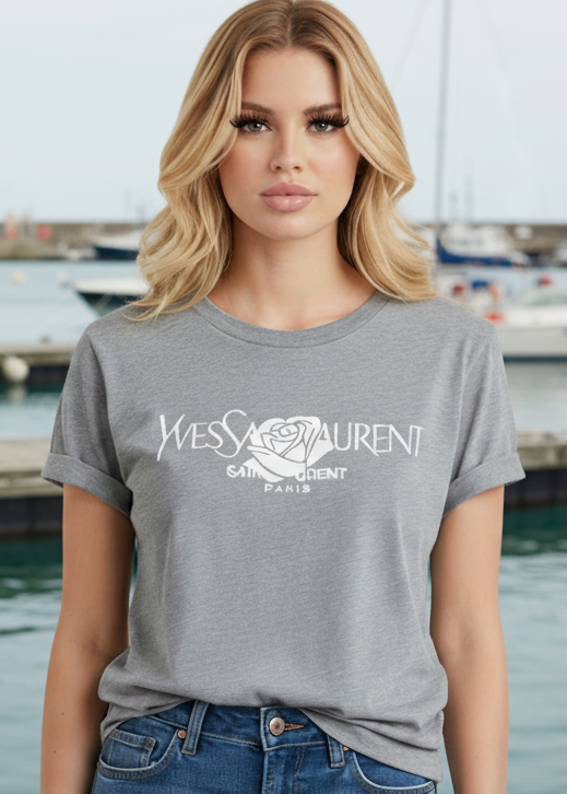 Woman wearing a gray t-shirt with a brand logo by a waterfront