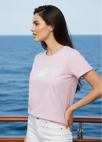 Woman wearing a pink YSL t-shirt with text, standing on a boat with ocean in the background
